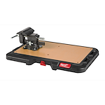 PACKOUT Customizable Work Top with a black and reddish design, featuring a mounted vise on a wooden work surface.