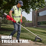 Person wearing a safety vest using a red Milwaukee string trimmer on a lawn near a building. Text: "MORE TRIGGER TIME."