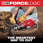 The M18 FORCE LOGIC Underground Cable Cutter is being used by a worker wearing gloves and jeans to cut a thick cable underground. The device is held with both hands, and the cutting process is taking place in a dirt trench.