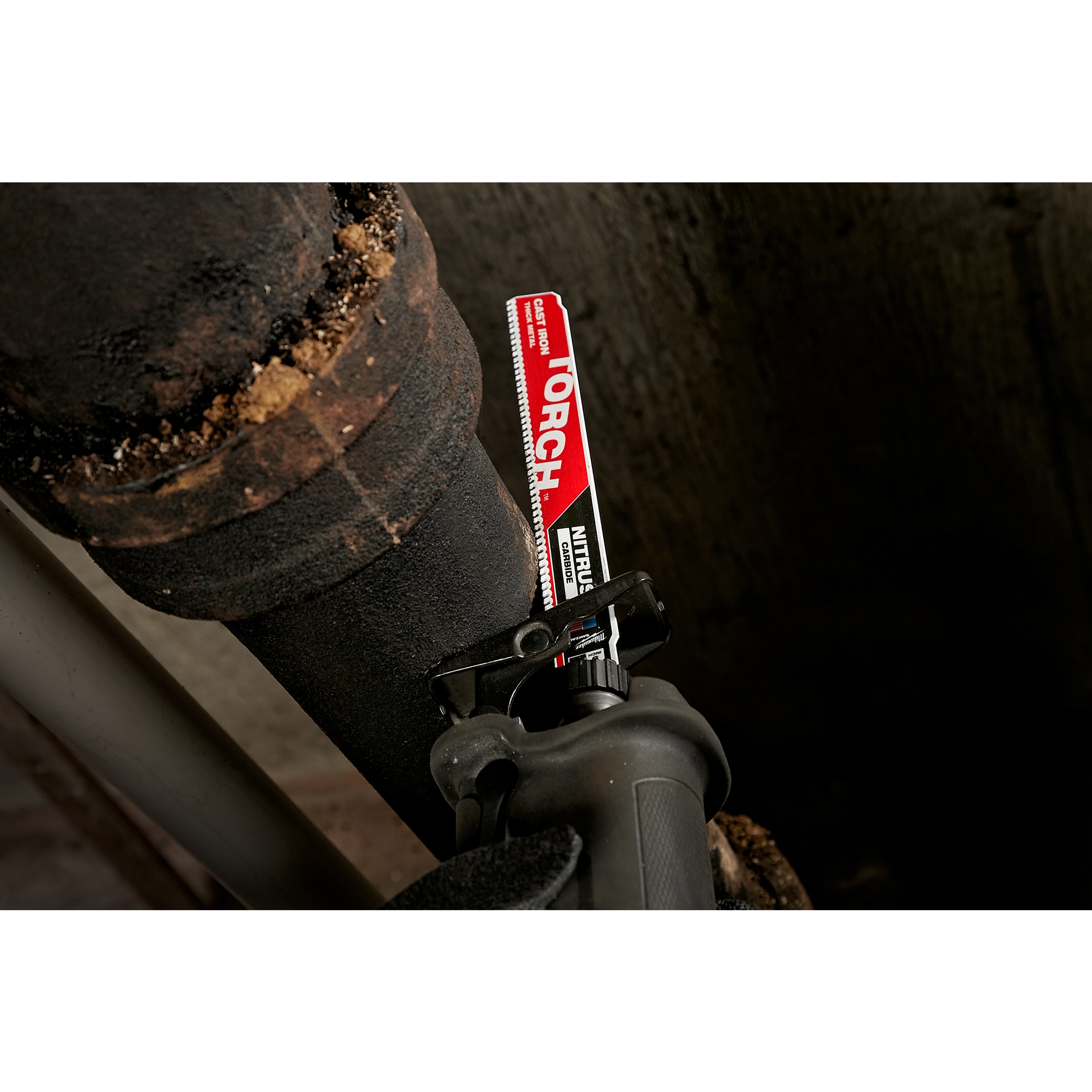 The Milwaukee 9" Cast Iron, Torch w. Nitrus Carbide Sawzall Blade is shown cutting through a thick, rusted iron pipe with ease.