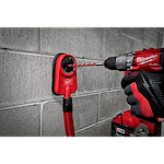 Hammer drill with a 1/2" X 10" X 12" hammer drill bit drilling into a concrete wall, with a dust extractor attached.