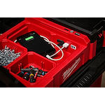 M12 PACKOUT Flood Light with USB Charging shown with various tools, screws, and a phone being charged inside a red tool organizer.
