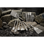 August 2023 Sledge Chisel Family Shot showing various sizes and types of chisels arranged on rocks in a construction setting.