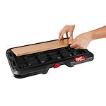 Hands placing a wooden panel on the PACKOUT Customizable Work Top, a black and red workbench with compartments.