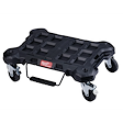 The PACKOUT Dolly is a black, heavy-duty rolling platform with a handle and four caster wheels, designed for transporting tools.