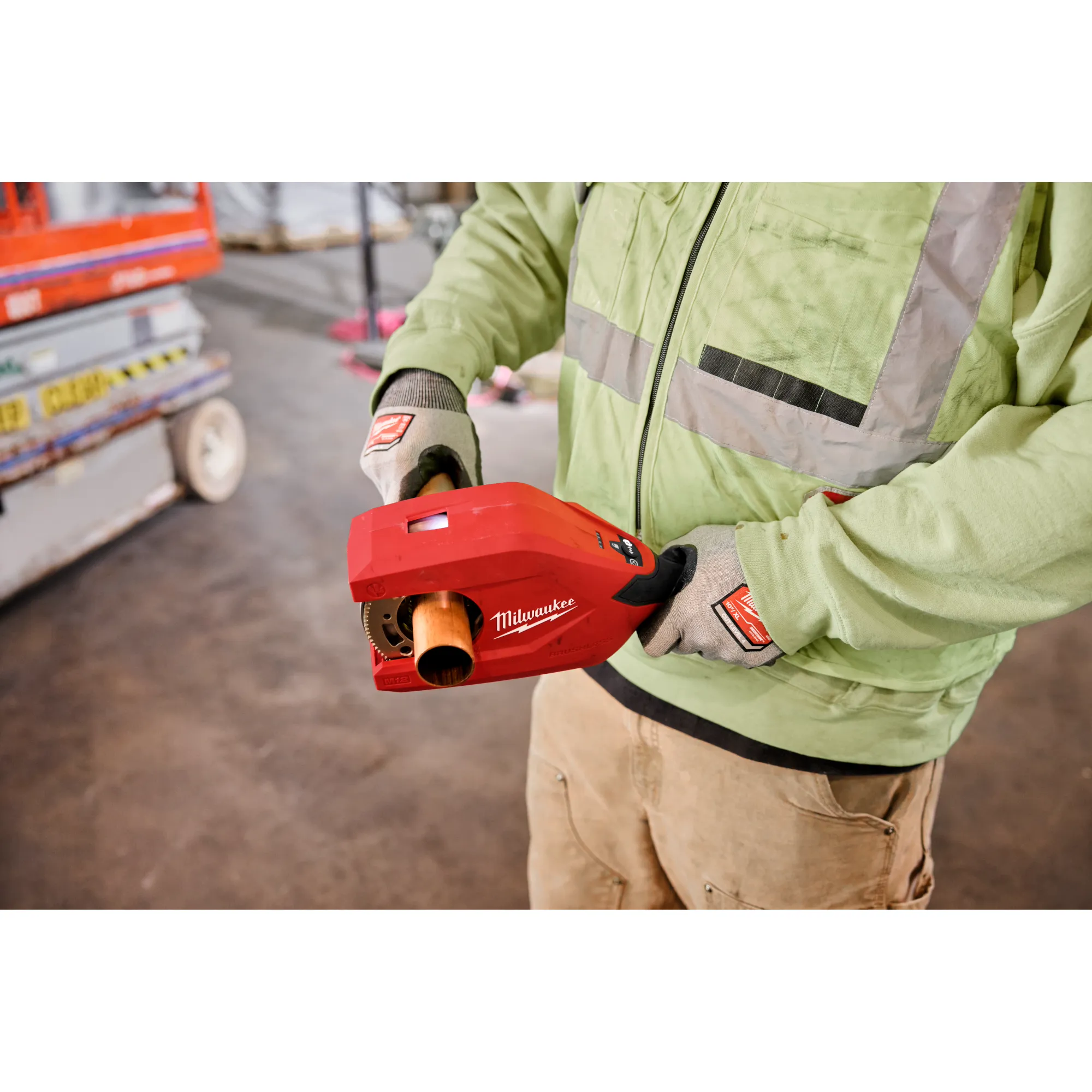 Image of the Milwaukee M12 Brushless 1-1/4" - 2" Copper Tubing Cutter being used by a worker on a jobsite to cut copper pipe