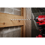 A 1/2" x 10" x 12" SHOCKWAVE Impact Duty Carbide Multi-Material Drill Bit being used to drill through a wooden board.