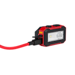 The Milwaukee® Rechargeable Magnetic Headlamp and Task Light features a rectangular, red and black body with a front-facing LED light and a red cable attached. It has two black buttons on top and a magnetic base for mounting.